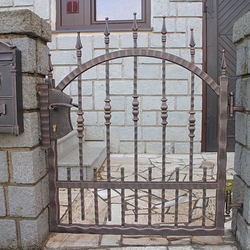 Schmiedeeiserner Zaun – geschmiedete Pforte mit verdichteten Elementen im unteren Teil 