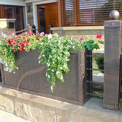 A wrought iron flowerpot in a fence