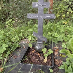 Monument en forg pour urne avec croix et inscription dans le jardin