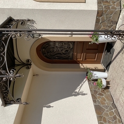 Wrought iron shelter with a romantic touch - entrance to the family house