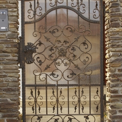 Portillon en fer forgé de qualité comme partie intégrante de la clôture d’une maison familiale Portillon en fer forgé de qualité comme partie intégrante de la clôture d’une maison familiale