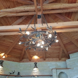 Wrought iron lamps in the garden gazebo with a forest motif