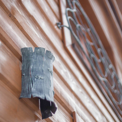 A wrought iron wall light of a tree bark design