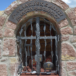 Forged monument of Saints with characteristic features: Tau sign, Bread