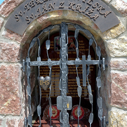 Monument forg des saints avec des attributs sur les grilles. Sainte Thrèse d'Avila