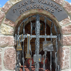 Schmiedeeisernes Denkmal der Heiligen mit Attributen auf dem Gitter. Stola und Brief mit der Aufschrift Bue
