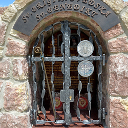 Monument forg des saints avec des attributs sur les grilles. Sainte Brigitte de Suède - bton, Saint Benot - mdaille