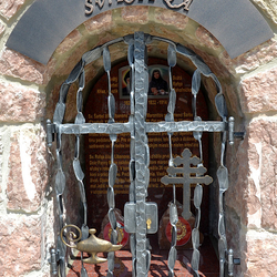 Monument forg des saints avec des attributs sur les grilles. Saint Charbel - rcipient avec du feu, Sainte Rafqa - croix libanaise
