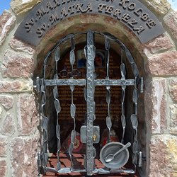 Monument forg. Saint Maximilien Kolbe - lunettes, Sainte Mère Teresa - bol avec une cuillère