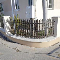 Geschmiedete Umzäunung eines älteren Einfamilienhauses in einfachem Stil - geschmiedetes Tor und Zaun