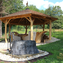 Hand-forged fireplace with fireplace tools in the garden of the cottage