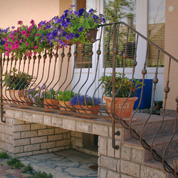 Wrought iron flower holders in an exterior railing Wrought iron flower holders in an exterior railing