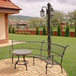 Mobilier forgé à la main et lampe sur pied dans le jardin d'une maison familiale Mobilier forgé à la main et lampe sur pied dans le jardin d'une maison familiale