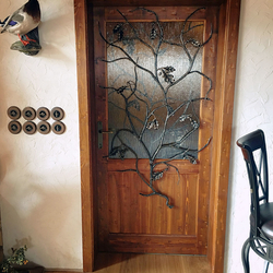 Grille forge artistique sur la porte en forme de branche de chêne
