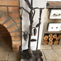 Hand-forged fireplace tools PINE by the outdoor fireplace in a summer house Hand-forged fireplace tools PINE by the outdoor fireplace in a summer house