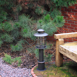 A wrought iron standard lamp in a garden A wrought iron standard lamp in a garden