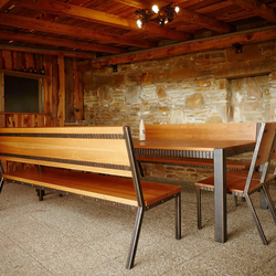 Modern wrought iron benches with a table in a combination with red spruce in a summer house of a family house Modern wrought iron benches with a table in a combination with red spruce in a summer house of a family house