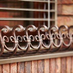 Forged flower pot holders on the windows of a family house Forged flower pot holders on the windows of a family house