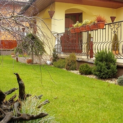 Forged flower pot holders on aporch railing at afamily home