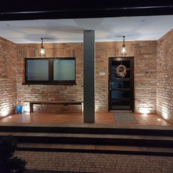 Evening view of the illuminated house entrance - forged exterior lightings Evening view of the illuminated house entrance - forged exterior lightings