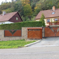 Tor aus Schmiedeeisen und Holz – Harmonie der Materialien – modernes Tor und Zaun an einem Einfamilienhaus