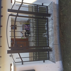 Portillon forgé comme partie intégrante de la clôture d'une maison individuelle Portillon forgé comme partie intégrante de la clôture d'une maison individuelle