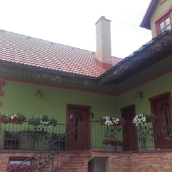 A view of a family house with a wrought-iron shed and railings with an oak pattern made in UKOVMI A view of a family house with a wrought-iron shed and railings with an oak pattern made in UKOVMI