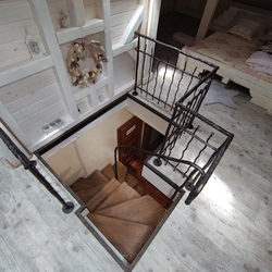 Blick auf den Zugang zum Dachgeschoss  geschmiedete Treppe mit Holzeinstiegsbrettern und Gelnder