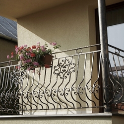 Flower holders on a forged balcony railing Flower holders on a forged balcony railing