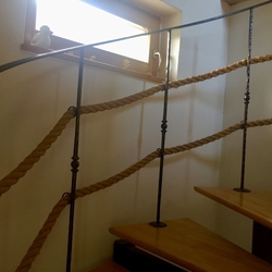 Forged railing with ropes for an interior helical staircase