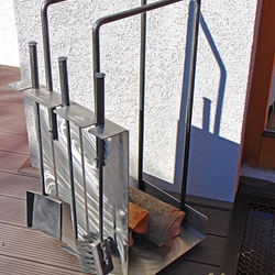A modern stainless steel firewood rack with fireplace tools A modern stainless steel firewood rack with fireplace tools