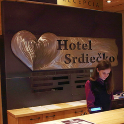A stainless steel sign with a logo - a hotel reception