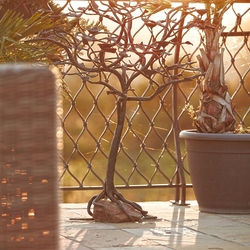 Luxuriser, schmiedeeiserner Kerzenleuchter auf einer Terrasse  handgeschmiedeter Kerzenleuchter BAUM