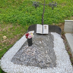 Croix en forme d'olivier, place sur une roche avec un livre ouvert qui raconte l'histoire du dfunt