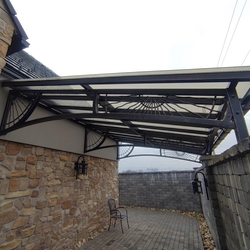 Abri design en fer forg, fabriqu par UKOVMI pour une maison familiale, assorti à un portail en fer forg