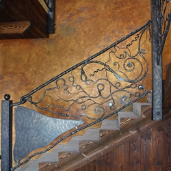 Rampe d'escalier d'un chalet de luxe. Garde-corps en fer forg au motif de racines. 