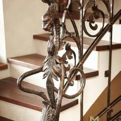 Dragon en fer forgé artisanal - détail approché d'un garde-corps pour escalier sur mesure.