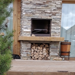 Forged fireplace accessories + a wooden basket with forged accessories on the outside Forged fireplace accessories + a wooden basket with forged accessories on the outside